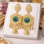 gold-plated traditional Indian jhumka earrings featuring a peacock design